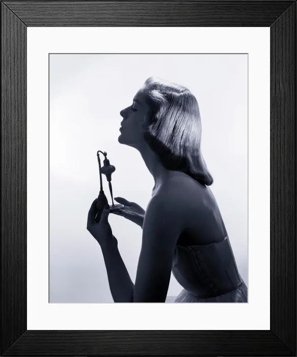 Framed Print : 1950s PROFILE PORTRAIT STYLISH ELEGANT YOUNG WOMAN HOLDING UP PERFUME ATOMIZER SPRAY BOTTLE Framed Print : 1950s PROFILE PORTRAIT STYLISH ELEGANT YOUNG WOMAN HOLDING UP PERFUME ATOMIZER SPRAY BOTTLE