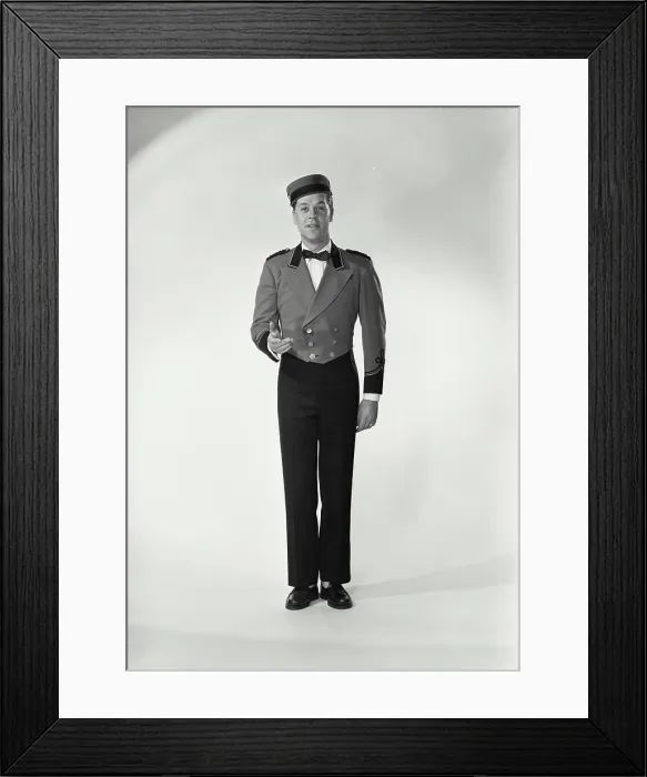 Framed Print : Vintage Photograph. Man wearing bellman uniform standing on white background Framed Print : Vintage Photograph. Man wearing bellman uniform standing on white background