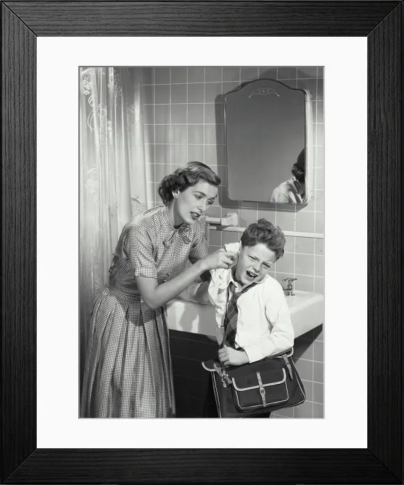 Framed Print : Vintage photograph. Mother cleaning unhappy young boys ear