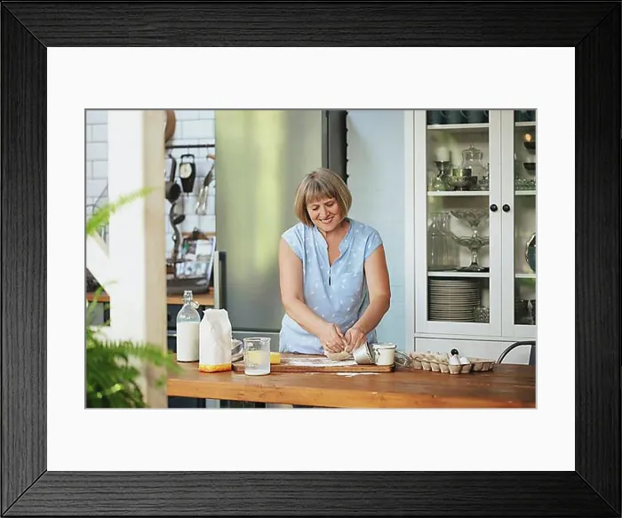 Framed Print : Happy senior woman housewife making kneading dough for pie while standing behind wooden table in kitchen with Framed Print : Happy senior woman housewife making kneading dough for pie while standing behind wooden table in kitchen with