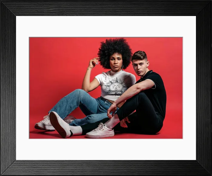Framed Print : Multiracial couple studio shooting over a red background Framed Print : Multiracial couple studio shooting over a red background