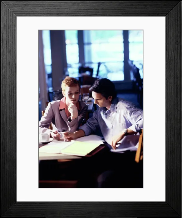 Framed Print : Businessman and a businesswoman sitting in a restaurant talking
