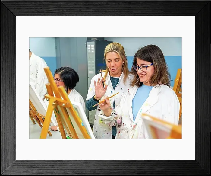 Framed Print : Happy woman with special needs painting in a canvas next to a teacher in the art class