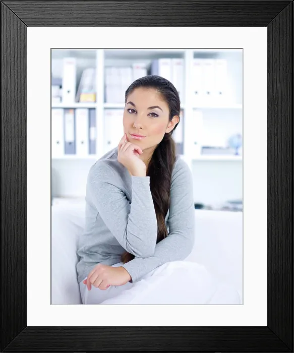 Framed Print : Daily life Young woman sitting on couch in her home Framed Print : Daily life Young woman sitting on couch in her home
