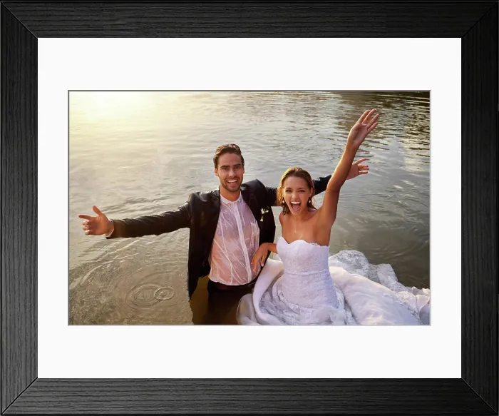 Framed Print : Lake, portrait of wet bride and groom standing in water together with excited smile and playful romance Framed Print : Lake, portrait of wet bride and groom standing in water together with excited smile and playful romance