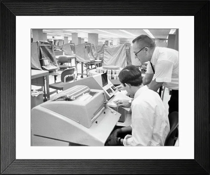 Framed Print : Office worker demonstrates the computer interrogation device for updating customer records Framed Print : Office worker demonstrates the computer interrogation device for updating customer records