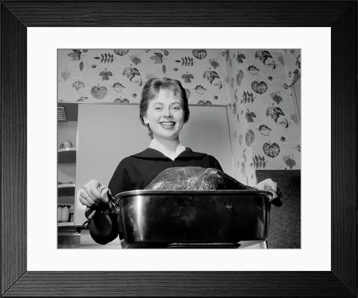 Framed Print : Young woman carrying roast turkey Framed Print : Young woman carrying roast turkey
