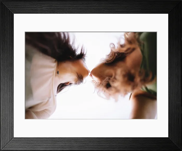 Framed Print : Low angle view of lesbian couple standing face to face about to kiss Framed Print : Low angle view of lesbian couple standing face to face about to kiss