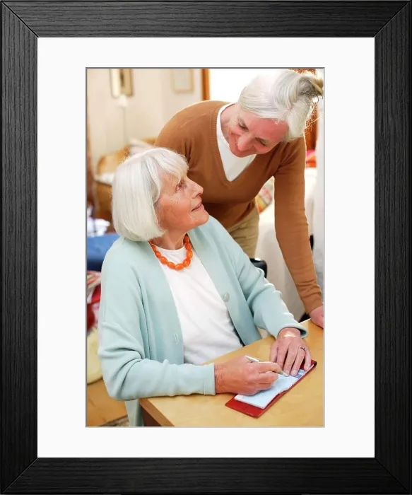 Framed Print : Woman helping elderly woman doing paperwork Framed Print : Woman helping elderly woman doing paperwork