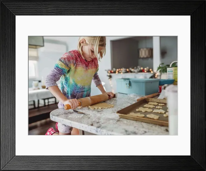 Framed Print : Girl Rolling out dough with Christmas lights in the background Framed Print : Girl Rolling out dough with Christmas lights in the background