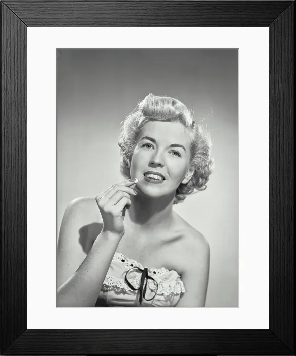 Framed Print : Vintage photograph. portrait of woman in strapless dress smiling at camera holding pill
