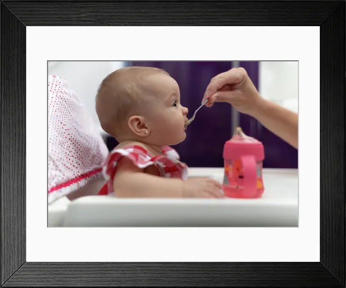 Framed Print : baby eating porridge, sela gives her mother Framed Print : baby eating porridge, sela gives her mother