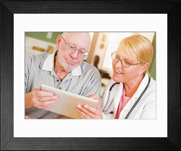 Framed Print : Female doctor or nurse showing senior man touch pad computer at home Framed Print : Female doctor or nurse showing senior man touch pad computer at home