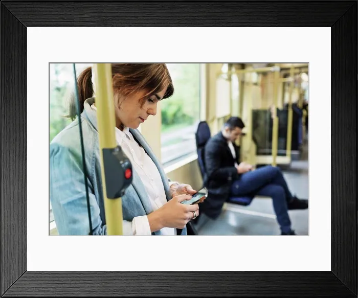 Framed Print : Young woman using mobile phone in tram Framed Print : Young woman using mobile phone in tram