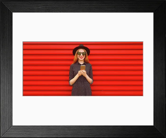 Framed Print : Porträt der stilvollen lächelnde Frau mit Smartphone trägt schwarzen runden Hut auf rotem Hintergrund Portrait of Framed Print : Porträt der stilvollen lächelnde Frau mit Smartphone trägt schwarzen runden Hut auf rotem Hintergrund Portrait of