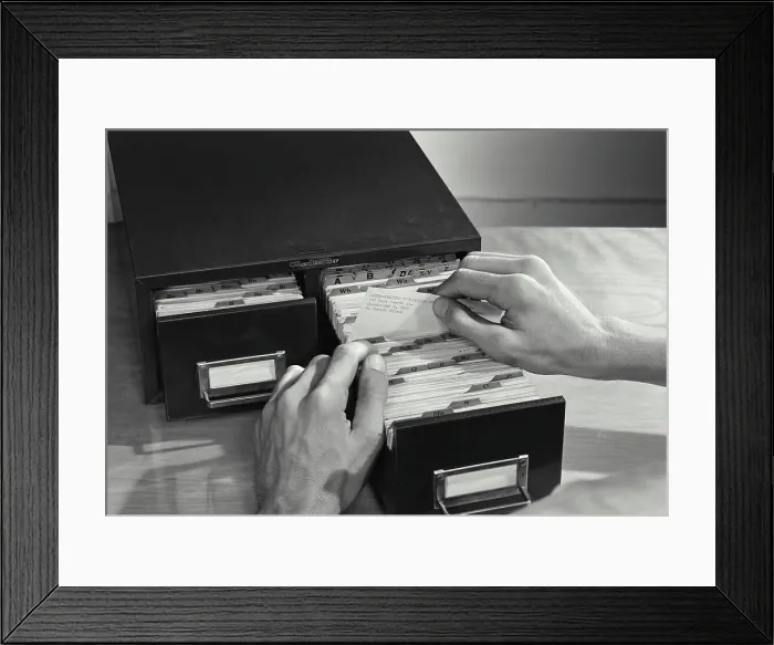 Framed Print : Vintage photograph. High angle view of a businessman filing cards in drawer Framed Print : Vintage photograph. High angle view of a businessman filing cards in drawer