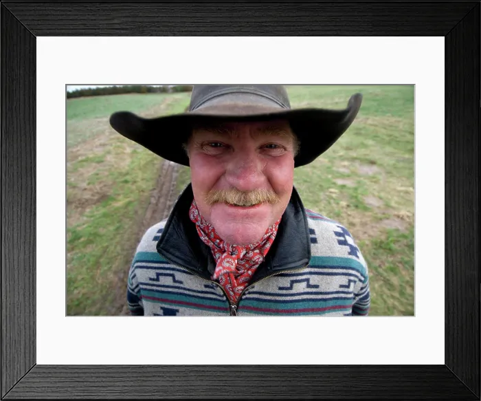 Framed Print : Outdoor portrait of a rancher with hat and moustache standing on his land near tire tracks; Burwell