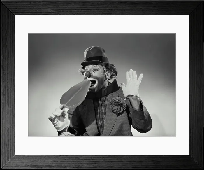Framed Print : Alfred Ward Model Released. Vintage Photograph. Hobo clown taking bite of oversized large lollipop