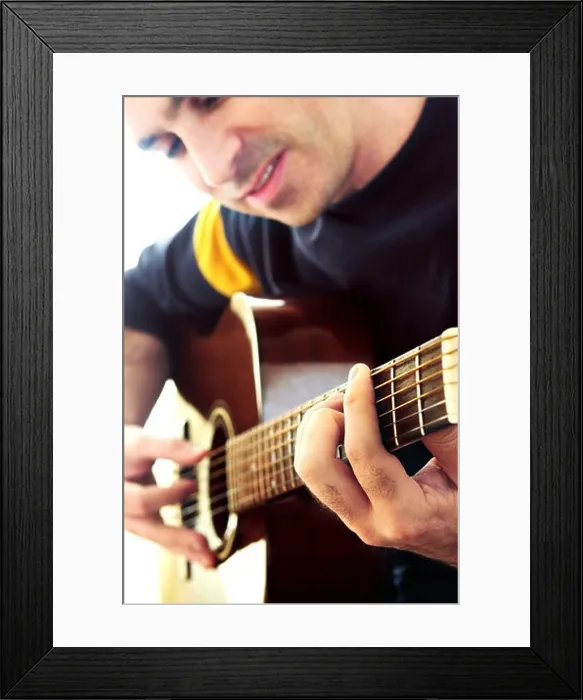 Framed Print : Man playing a musical instrument accoustic guitar
