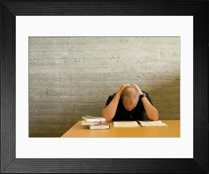 Framed Print : Young man reading and studying in a library Framed Print : Young man reading and studying in a library