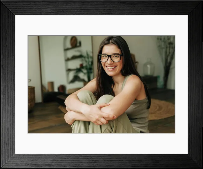 Framed Print : Close-up portrait of a beautiful happy brunette woman in glasses sitting on the floor Framed Print : Close-up portrait of a beautiful happy brunette woman in glasses sitting on the floor