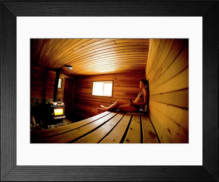 Framed Print : A young woman recouping after skiing in the sauna at Sol Mountain Lodge, British Columbia