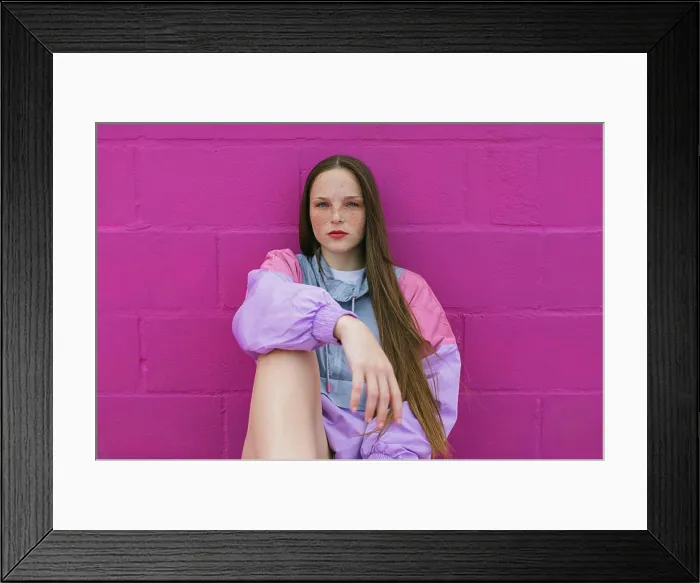 Framed Print : Trendy teenager with roller skates sitting near pink wall Framed Print : Trendy teenager with roller skates sitting near pink wall
