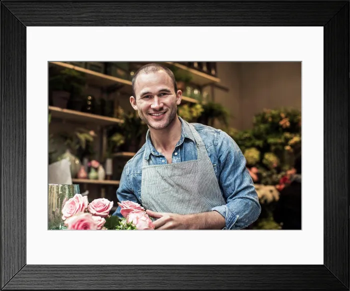 Framed Print : Portrait of happy male florist standing with flowers at shop Framed Print : Portrait of happy male florist standing with flowers at shop