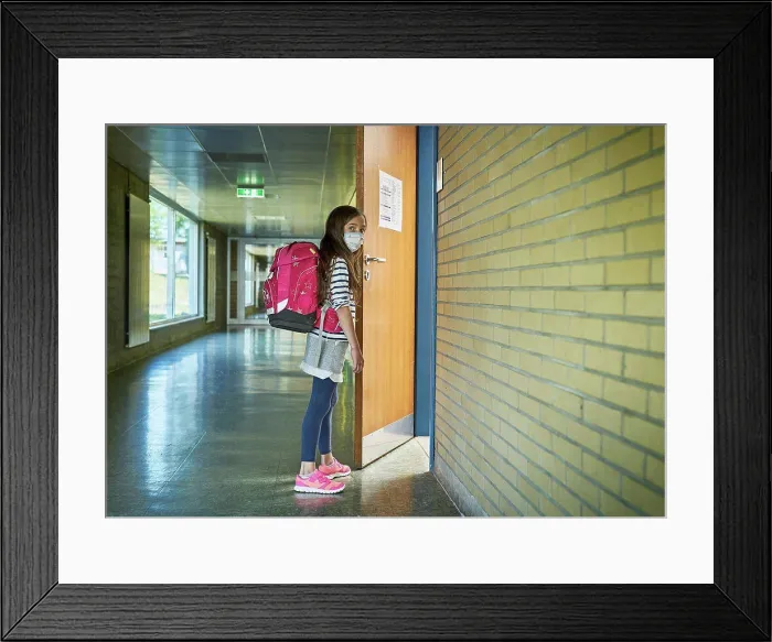 Framed Print : Girl wearing mask in school opening classroom door