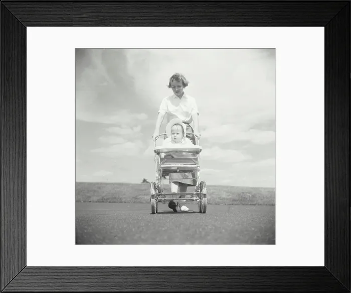 Framed Print : Young woman pushing her baby in a baby stroller Framed Print : Young woman pushing her baby in a baby stroller