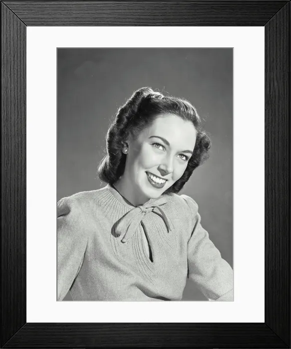 Framed Print : Vintage photograph. Brunette woman wearing sweater blouse with tie on collar smiling looking up