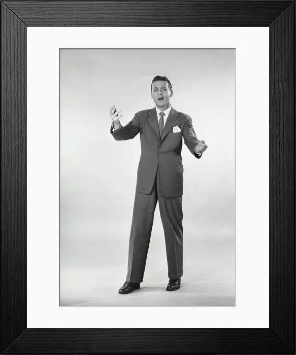 Framed Print : Vintage photograph. Man in suit standing with arms raised Framed Print : Vintage photograph. Man in suit standing with arms raised