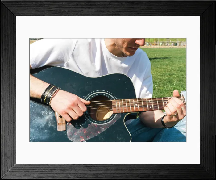 Framed Print : close up of a singer playing guitar in a garden during a sunny day
