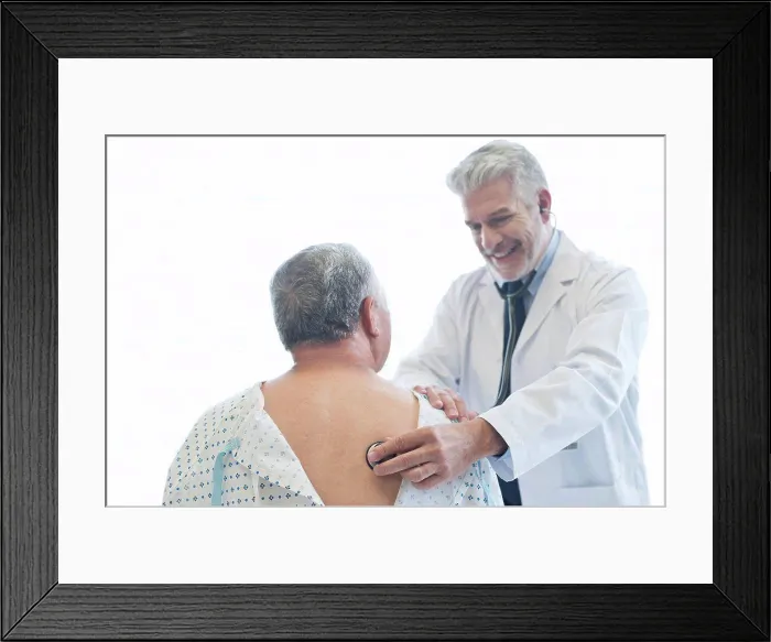 Framed Print : Male doctor examining patient in hospital gown