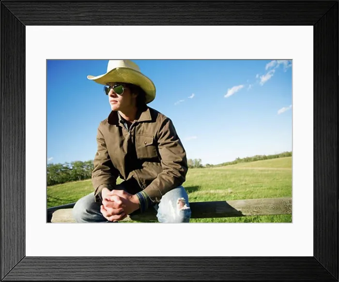 Framed Print : Man sitting on a fence