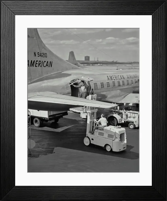 Framed Print : Vintage photograph. Man opening cargo door on American Airlines plane while standing on forklift pallet Framed Print : Vintage photograph. Man opening cargo door on American Airlines plane while standing on forklift pallet