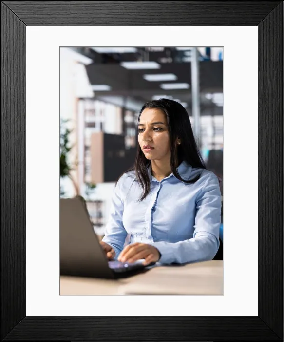 Framed Print : Female executive analyst finalizes a financial report and reviews data Framed Print : Female executive analyst finalizes a financial report and reviews data