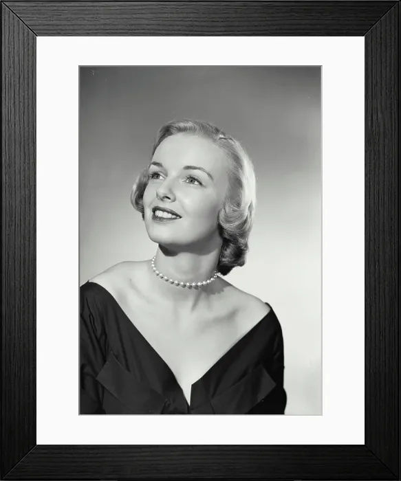 Framed Print : Vintage Photograph. Smiling blonde woman wearing black evening gown and pearl necklace looking up and off camera Framed Print : Vintage Photograph. Smiling blonde woman wearing black evening gown and pearl necklace looking up and off camera