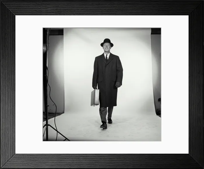 Framed Print : Studio portrait of businessman carrying briefcase Framed Print : Studio portrait of businessman carrying briefcase