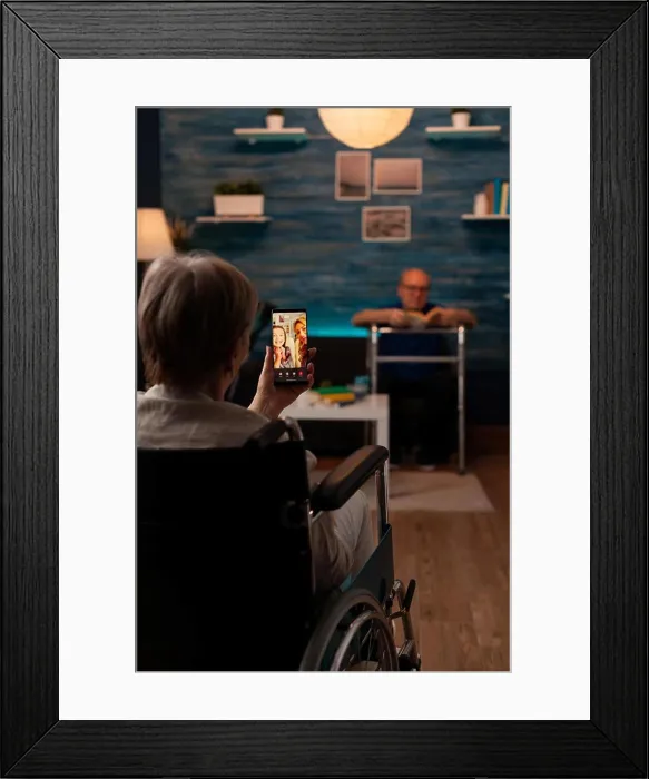Framed Print : Aged disabled woman holding smartphone for video call Framed Print : Aged disabled woman holding smartphone for video call
