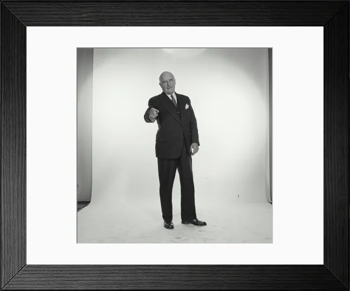 Framed Print : Studio portrait of senior businessman pointing forward