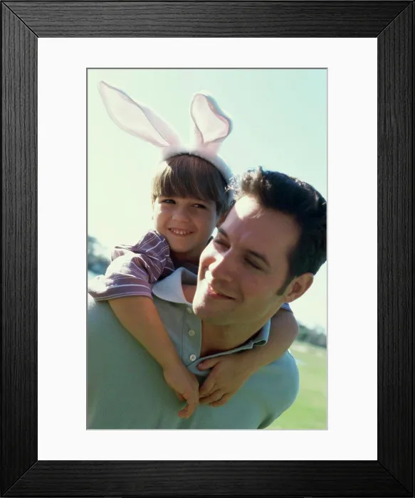 Framed Print : Son riding piggyback on his father