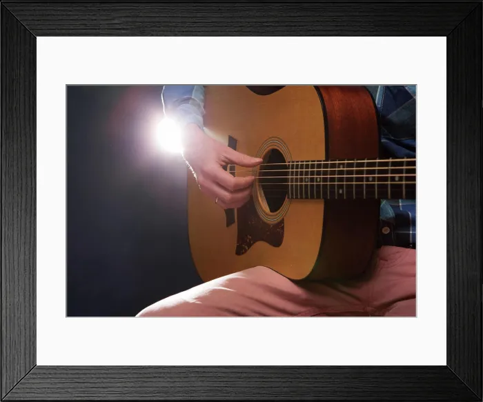 Framed Print : Man playing on acoustic guitar Man playing on acoustic guitar on dark background Copyright: xZoonar