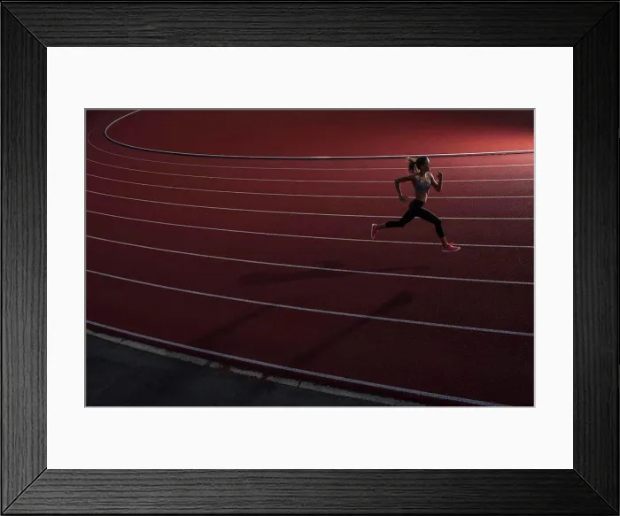 Framed Print : High angle view of young female athlete running on race track Framed Print : High angle view of young female athlete running on race track