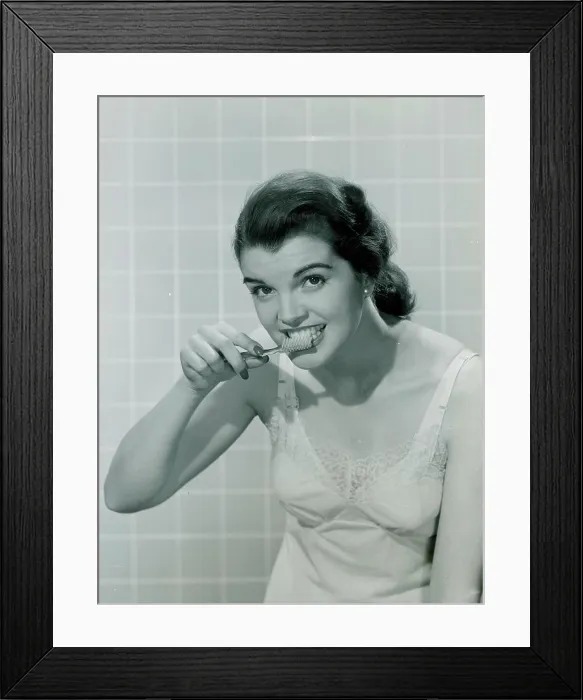 Framed Print : Young woman brushing teeth Framed Print : Young woman brushing teeth