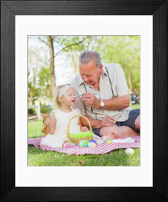 Framed Print : Loving grandfather and granddaughter coloring easter eggs together on picnic blanket at the park Framed Print : Loving grandfather and granddaughter coloring easter eggs together on picnic blanket at the park