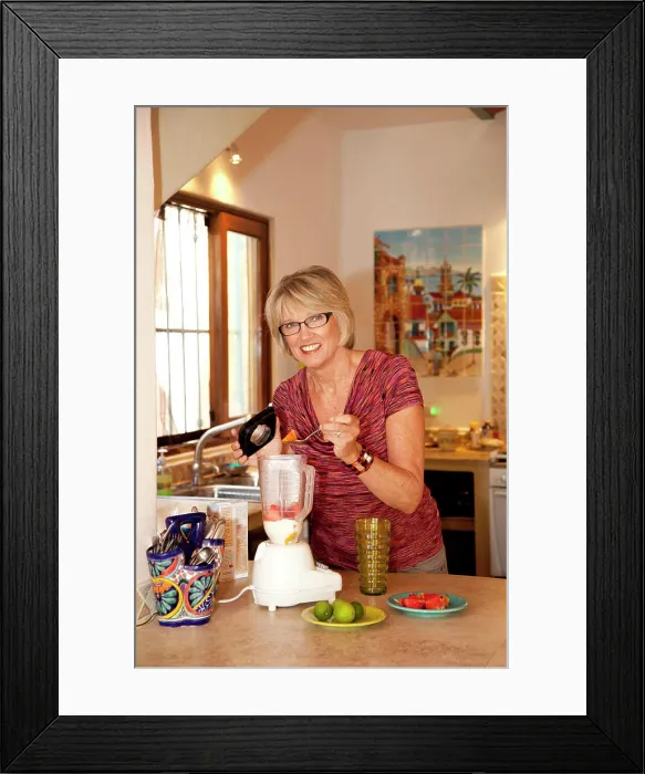 Framed Print : Woman making smoothie in kitchen blender Framed Print : Woman making smoothie in kitchen blender