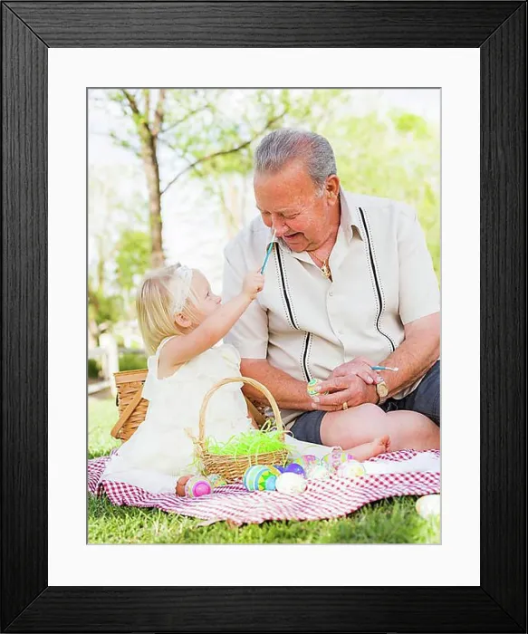 Framed Print : Loving grandfather and granddaughter coloring easter eggs together on picnic blanket at the park Framed Print : Loving grandfather and granddaughter coloring easter eggs together on picnic blanket at the park