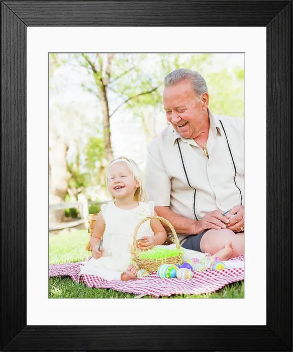Framed Print : Loving grandfather and granddaughter coloring easter eggs together on picnic blanket at the park Framed Print : Loving grandfather and granddaughter coloring easter eggs together on picnic blanket at the park