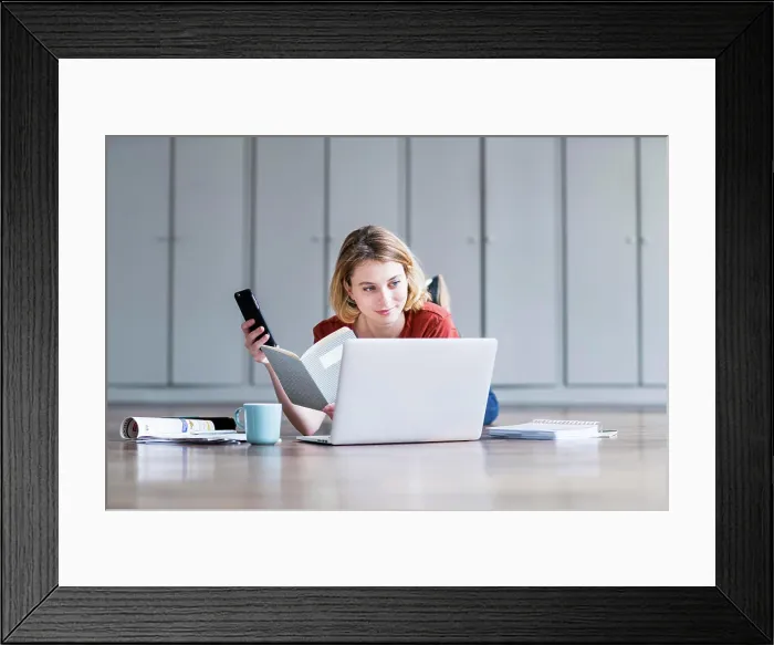 Framed Print : Woman using a laptop and a smartphone
